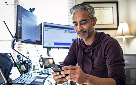 man in front of two screens