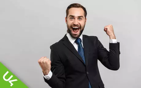 Man in suit, arms in the air, celebrating